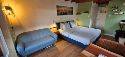 a small bedroom with a bed and a couch at The Shed in De Cocksdorp
