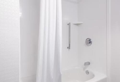 a shower with a white curtain and a sink at Hampton Inn By Hilton Wichita Northwest in Wichita