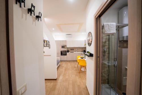 ein Flur, der zu einer Küche mit einem gelben Stuhl führt in der Unterkunft Casa Penelope Lucrino in Pozzuoli