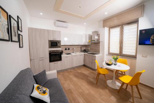 eine Küche und ein Wohnzimmer mit einer Couch und einem Tisch in der Unterkunft Casa Penelope Lucrino in Pozzuoli