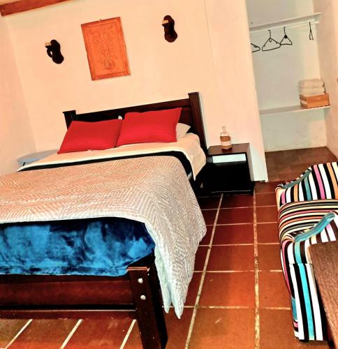 a bedroom with a bed with red pillows on it at Hotel Marrokos Aeropuerto José María Córdova in Rionegro