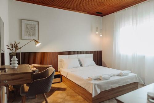 a bedroom with a bed and a desk and a deskablish at Nikolaidis Villa Family Friendly in Nea Kallikrateia