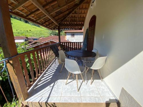 a patio with a table and chairs on a balcony at LUMIAR TEMPORADA CASA VILAREJO COM WI-fi TV A CABO PERTINHO DO POÇO FEIO E DA PRAÇA CENTRAL in Lumiar