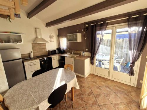 Il comprend une cuisine avec une table et un balcon. dans l'établissement Résidence La Pecherie 1 - VILLA T1 MEZZ 4 couchages LE BARCARES MAE-8473, au Barcarès