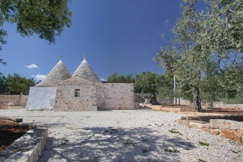 an old stone building with two thatched roofs at Trullo San Giovanni in Castellana Grotte