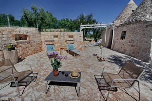 a patio with chairs and a table and a fireplace at Trullo San Giovanni in Castellana Grotte
