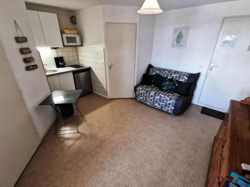 un petit salon avec un canapé et une cuisine dans l'établissement Résidence Le Lamparo - Appartement T2 4 couchages à Port Leucate. Réf: 4LAM_49B MAE-8503, à Leucate