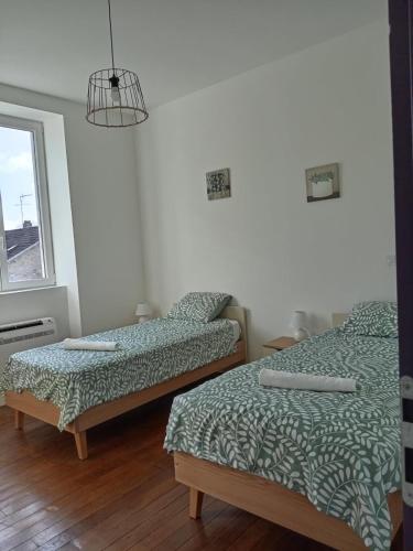 une chambre avec deux lits et une fenêtre dans l'établissement Ancienne Poste de Montcaret, à Montcaret