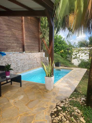 a swimming pool in a yard with a patio at La Casa Luna in Le Vauclin