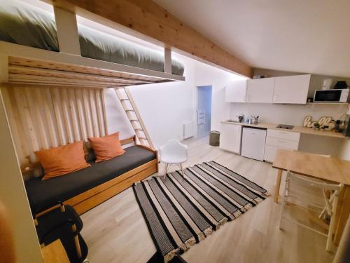 Cette petite chambre comprend un lit et une cuisine. dans l'établissement maisonnette jardin paris disney, à Neuilly-Plaisance