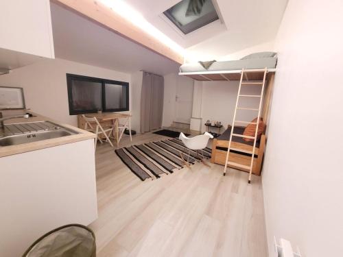 Il comprend un salon avec des lits superposés et une cuisine. dans l'établissement maisonnette jardin paris disney, à Neuilly-Plaisance