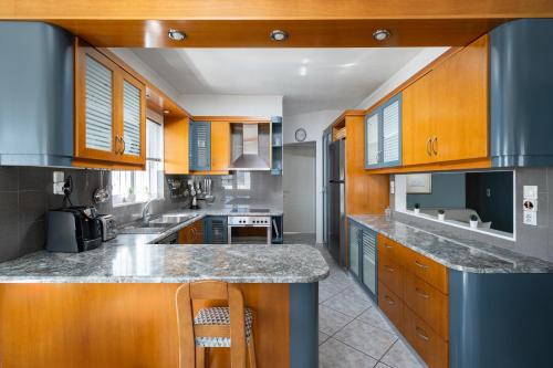 a large kitchen with wooden cabinets and granite counter tops at Serenity Guesthouse in Sitia