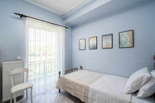 a blue bedroom with a bed and a window at Serenity Guesthouse in Sitia