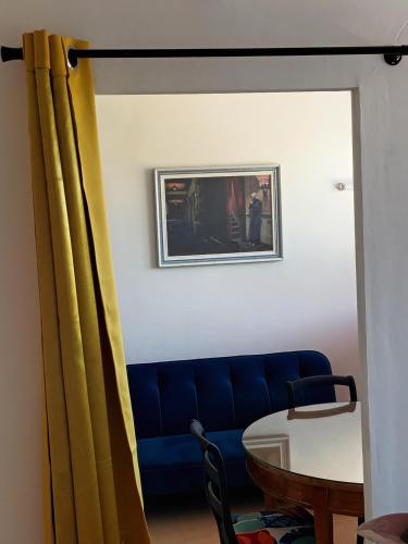 un salon avec un canapé bleu et une table dans l'établissement T1 Plage à proximité, à La Ciotat