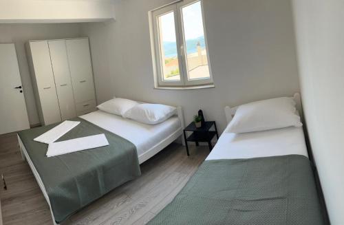 a bedroom with two beds and a window at Apartman Ante in Neum