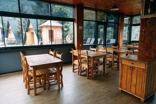 a restaurant with wooden tables and chairs and windows at Vaio Resort in Keda in Keda