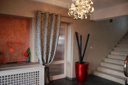 a living room with a staircase and a chandelier at Hôtel Restaurant le Panorama in Évian-les-Bains