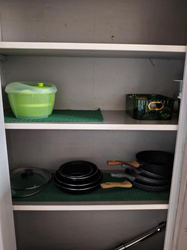 a shelf with pans and a bowl on it at l'Orchidée - 100m Naval group - 5mn de l'espace Carat in Magnac-sur-Touvre