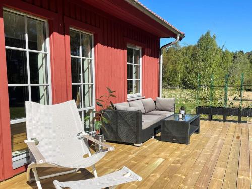 a patio with a couch and chairs on a deck at 5 person holiday home in KLÖVEDAL-By Traum in Klövedal