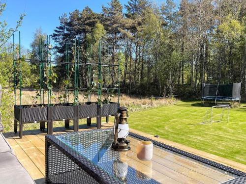 a glass table with a bottle on top of it on a patio at 5 person holiday home in KLÖVEDAL-By Traum in Klövedal