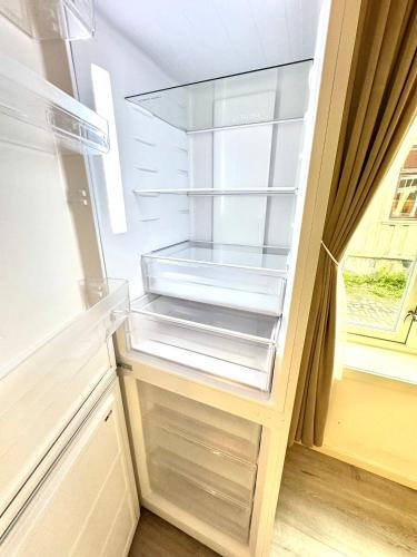 an empty refrigerator with its door open in a kitchen at Stor attraktiv studioleilighet i sentrum in Trondheim