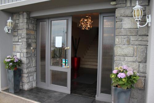 a entrance to a building with two vases of flowers at Hôtel Restaurant le Panorama in Évian-les-Bains
