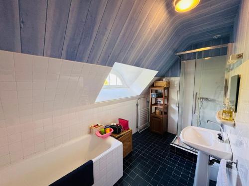 une salle de bain avec une baignoire blanche et un lavabo dans l'établissement Maison familiale, 8 chambres, jardin clos 3000m, wifi, parking, à La Trinité-sur-Mer