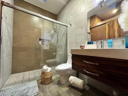 a bathroom with a toilet and a glass shower at Beautiful House with Climate Pool and Jacuzzi in Colima