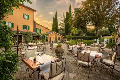 a restaurant with tables and chairs in a courtyard at I Capricci Di Merion - Resort & Spa in Tuoro sul Trasimeno