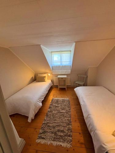 a attic bedroom with two beds and a window at Norrqvarn Hotel & Resort by Vänerport in Lyrestad