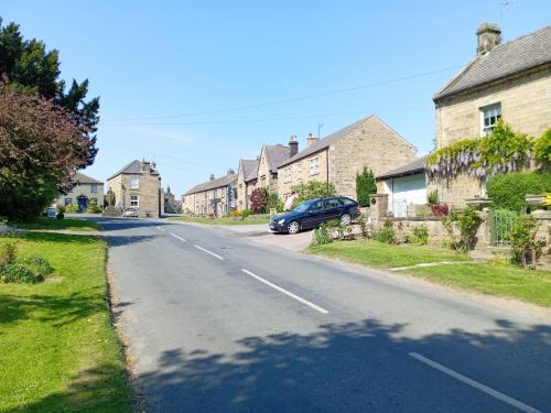 a street with houses and a car parked on the road at Gospatric House in Ripon