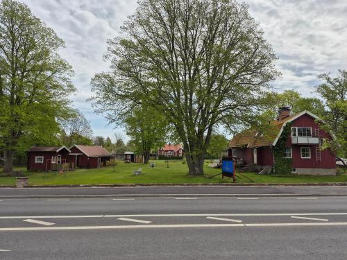 an empty street with houses and a tree at Morgonljus B&B-edith&julia-Self check-in in Rälla