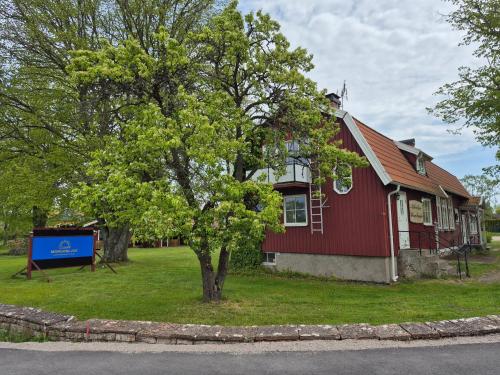 a red house with a tree in front of it at Morgonljus B&B-edith&julia-Self check-in in Rälla