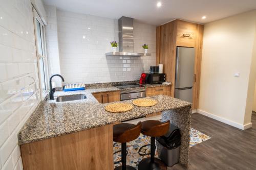 een keuken met een wastafel en een aanrecht met krukken bij Casa nueva en el Centro in Santander