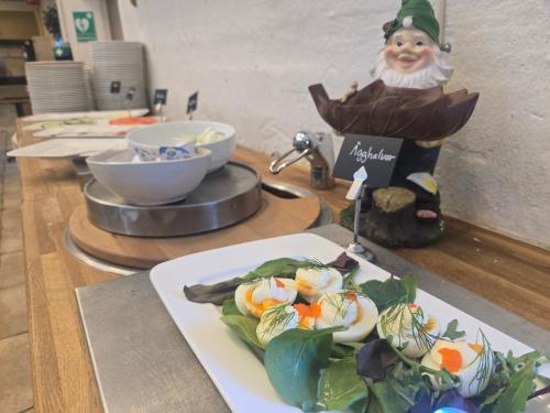 a plate of vegetables on a table with a statue at Norrqvarn Hotel & Resort by Vänerport in Lyrestad