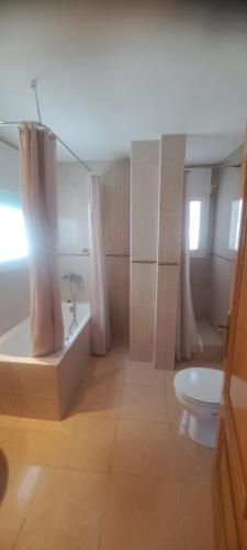 a bathroom with a tub and a shower and a toilet at Jordi's Flat close to the Beach in L'Estartit