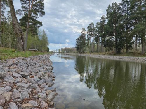 a river with rocks and trees on the side at Norrqvarn Hotel & Resort by Vänerport in Lyrestad