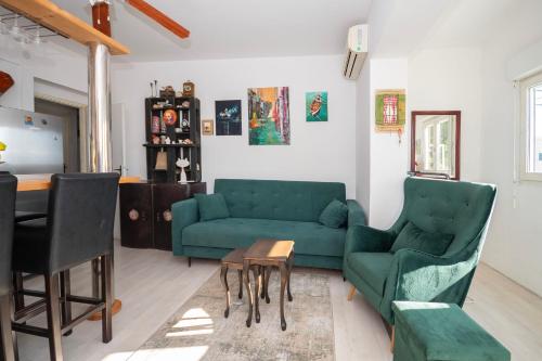 een woonkamer met een groene bank en een tafel bij Apartment Renko in Omiš