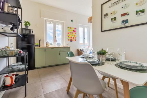 Una cocina y un comedor con una mesa y sillas blancas. en Mike&Jo Apartments, en Ostia Antica
