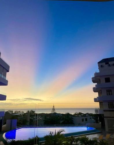 a view of a swimming pool at sunset from a building at Kensington Seaviews in Flic-en-Flac