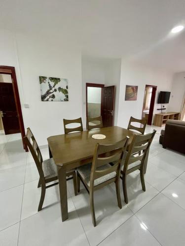 a wooden table and chairs in a living room at Kensington Seaviews in Flic-en-Flac