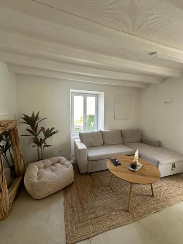 a living room with a couch and a coffee table at Maison Cosy Niort parking privé 3 chambres in Niort