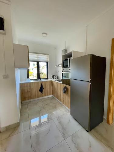 a kitchen with a stainless steel refrigerator and a window at Kensington Seaviews in Flic-en-Flac