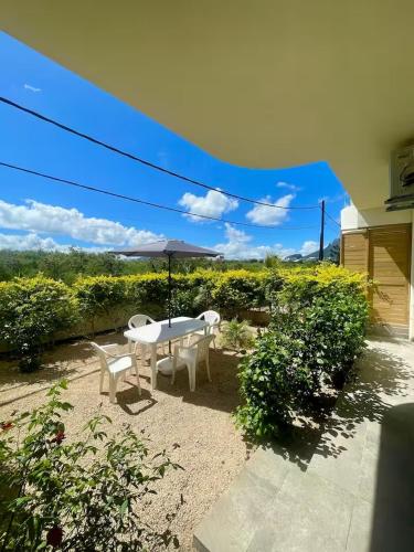 a table and chairs and an umbrella in a yard at Kensington Seaviews in Flic-en-Flac