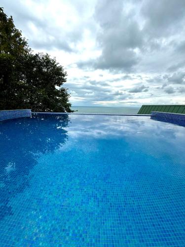 a large blue swimming pool with the ocean in the background at Marco Polo Sarpi Vila 3 in Batumi