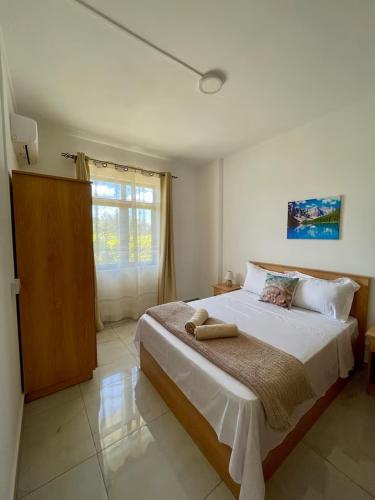 a bedroom with a large bed with a window at Kensington Seaviews in Flic-en-Flac