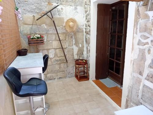 une chambre avec une table, une chaise et une porte dans l'établissement Le refuge, à Arles