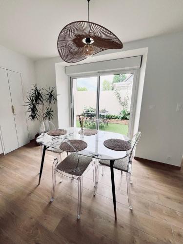 une salle à manger avec une table et des chaises blanches dans l'établissement Maison entièrement rénovée Plérin centre, à Plérin