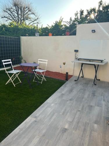 a ping pong table and chairs in a backyard at Le Coin Charmant - vue montagnes et jacuzzi privé in Privas