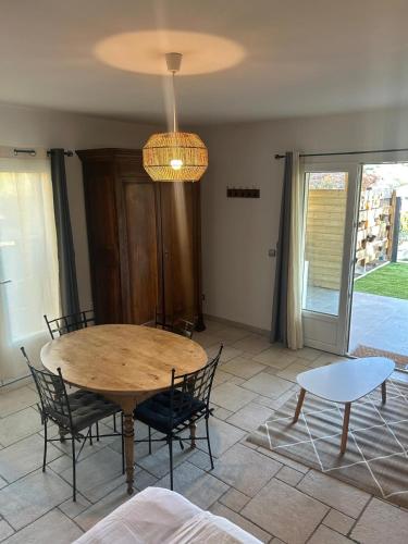 a dining room with a wooden table and chairs at Le Coin Charmant - vue montagnes et jacuzzi privé in Privas